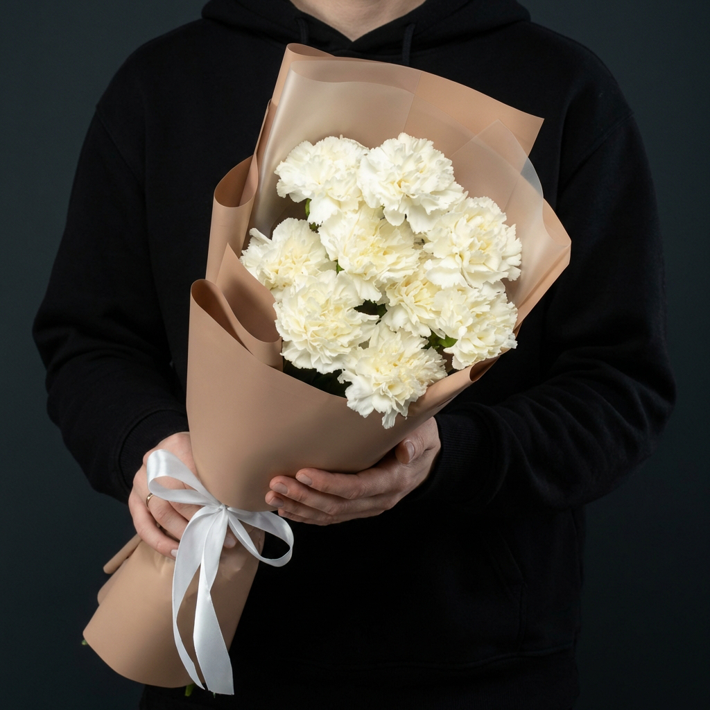 7 белых гвоздик в бежевой упаковке